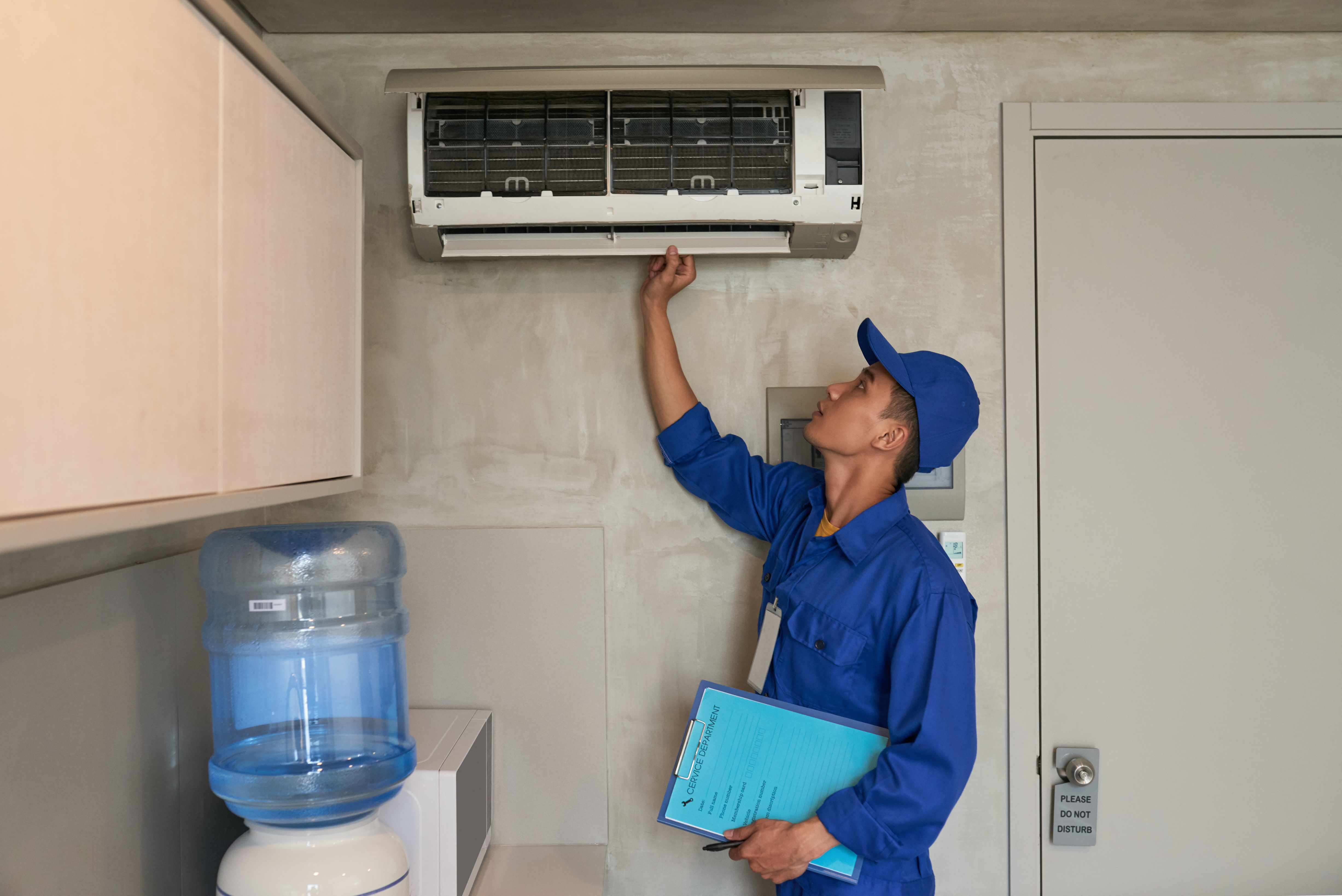 Engineer performing air conditioning maintenance